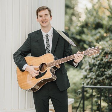 Reagan playing guitar between white columns