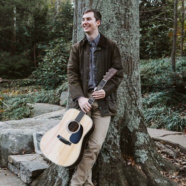 Reagan with his guitar in the forest